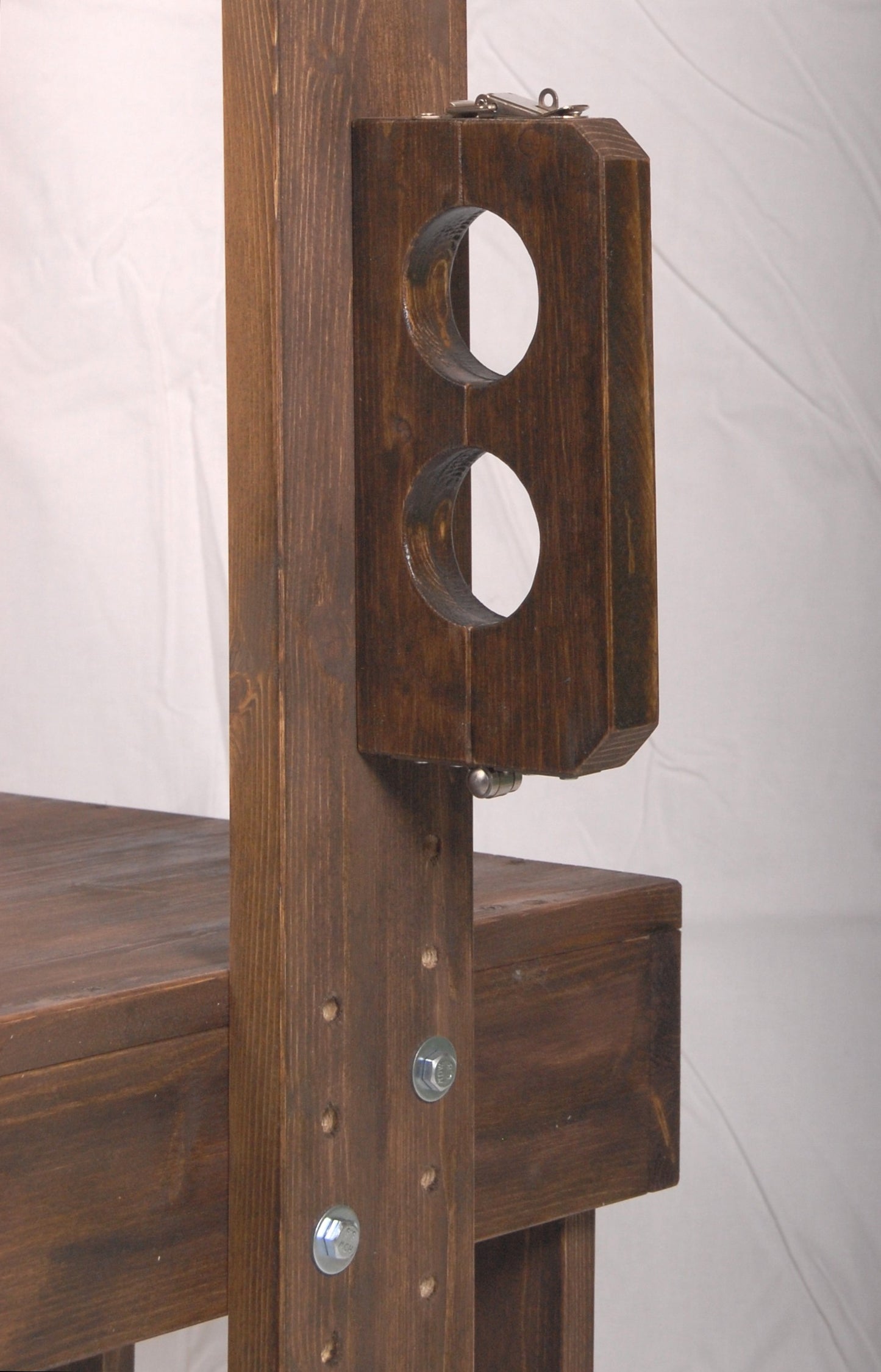 Adjustable bondage stocks on the wooden interrogation chair.