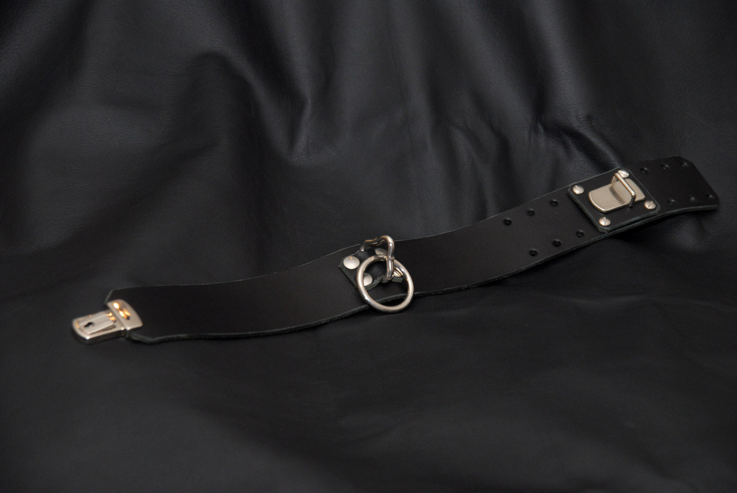 Italian-crafted lockable black leather collar with stainless steel O-ring for secure bondage scenes