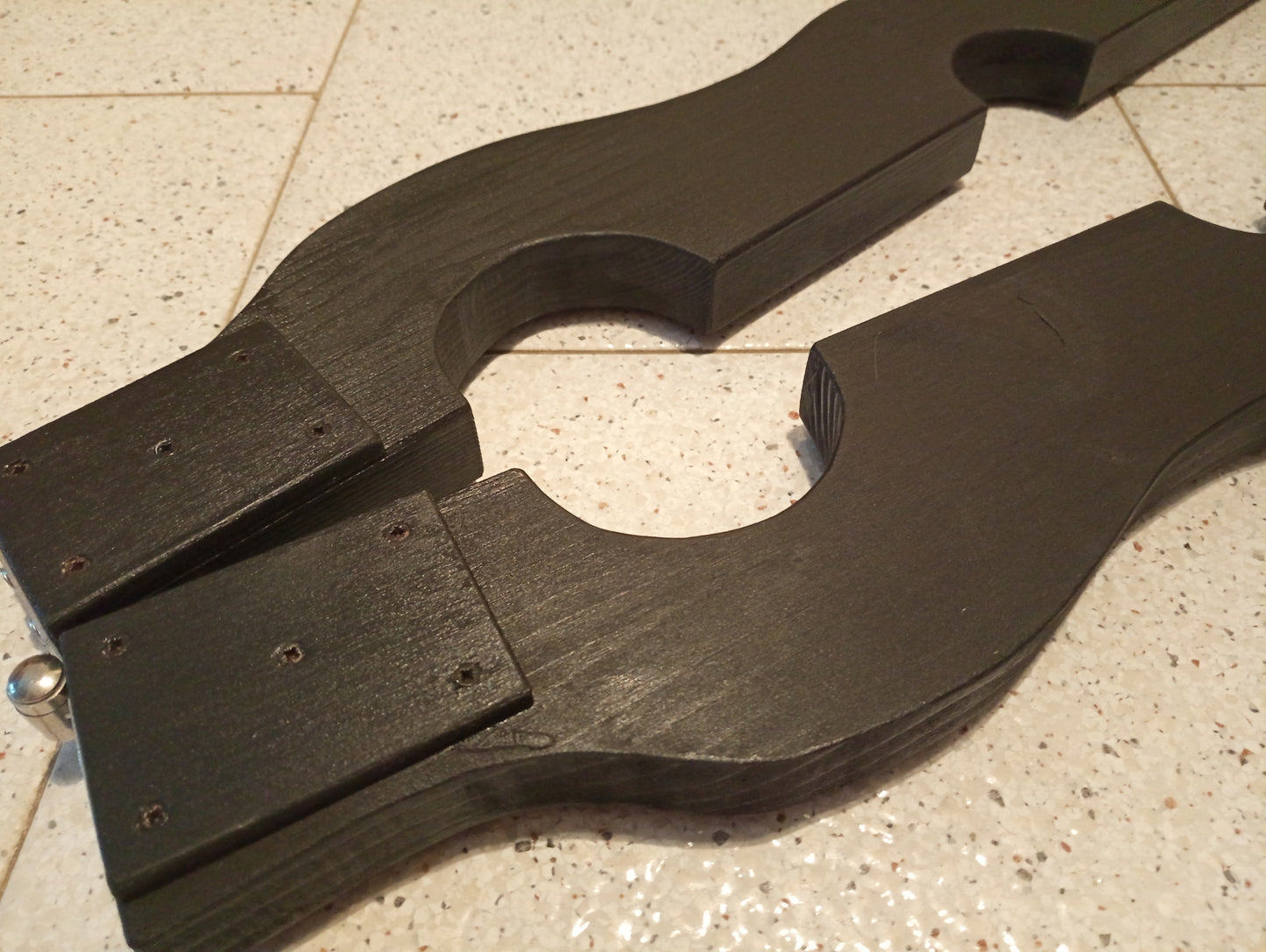 Sleek black bondage stock made from durable fir wood, ideal for BDSM.