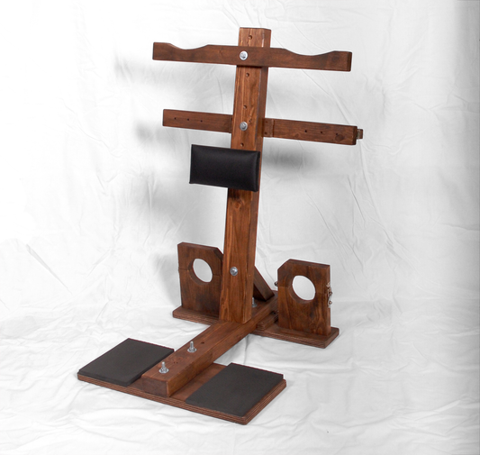 Domination hanger kneeling bench with wrist and ankle stocks for BDSM dungeon use.