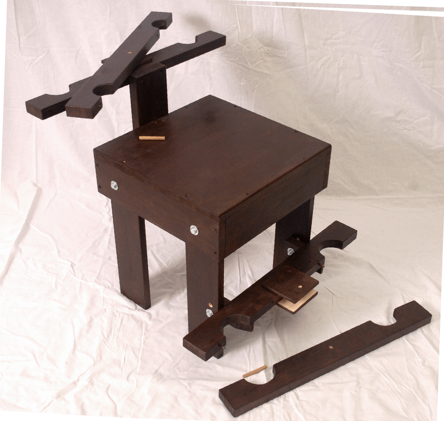 Front view of BDSM wooden chair with wrist and ankle restraints, suitable for dungeon furniture.