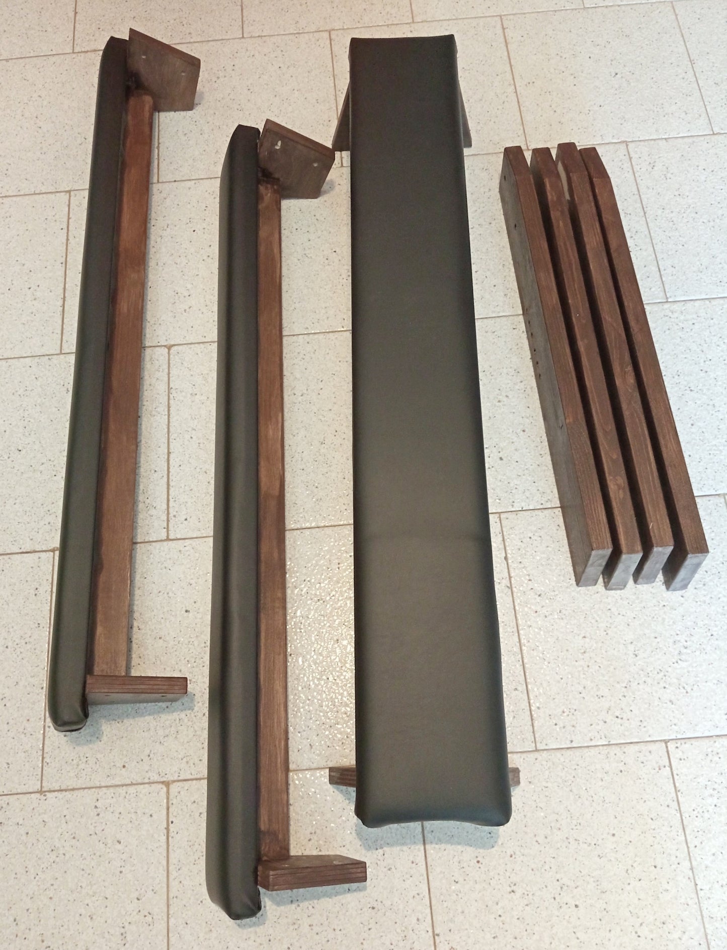 Disassembled portable spanking bench showing compact modular components for easy transport and storage.